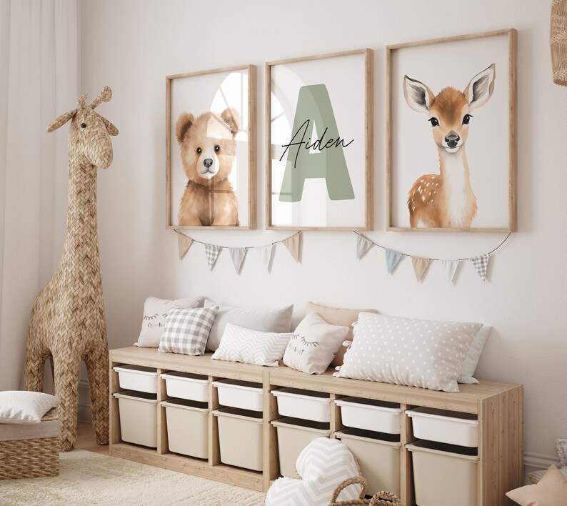 May include: A nursery room with a wooden storage bench, three framed prints with a teddy bear, a deer, and the letter A with the name Aiden, and a woven giraffe toy.