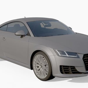 Puede incluir: Un Audi TT coupé de color gris plata con detalles en negro. El coche tiene una parrilla negra con el logotipo de Audi y espejos laterales negros.