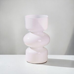 Peut inclure: Un vase en c&eacute;ramique blanc avec un design arrondi et bulbeux. Le vase a une finition lisse et brillante et est parfait pour pr&eacute;senter des fleurs ou de la verdure.