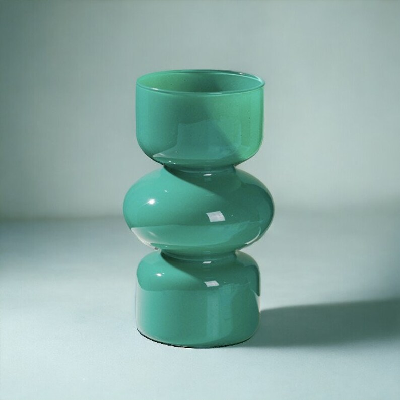 Peut inclure: Un vase en verre bleu turquoise avec un design unique &agrave; trois niveaux arrondis.