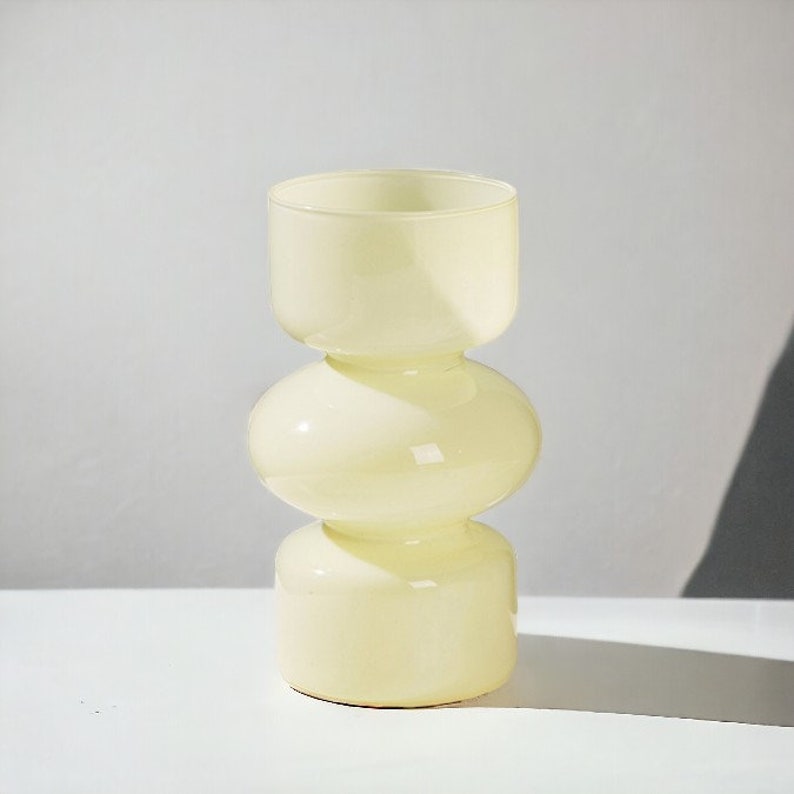 Peut inclure: Un vase en verre jaune p&acirc;le avec un design unique, arrondi et &agrave; trois niveaux.