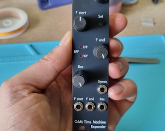 May include: A black electronic module with knobs and jacks, labeled "OAM Time Machine Expander." It features controls for "Mode," "F start," "Set," "F end," and "Res." The module also has "LPF," "BPF," and "HPF" indicators, along with "Stereo" jacks.