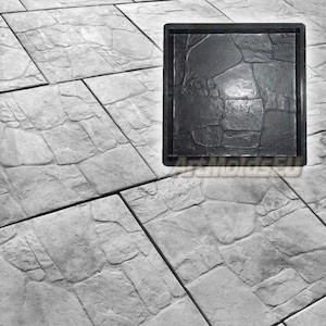Puede incluir: Un molde de plástico negro para crear adoquines de hormigón. El molde presenta un diseño texturizado que se asemeja a un patrón de piedra.