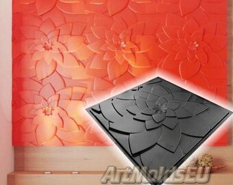 May include: A black silicone mold for creating a wall panel with a floral design. The mold is square and features a large, detailed flower in the center. The mold is shown against a background of a wall panel that has been created using the mold.