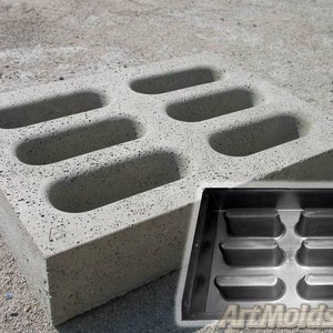 May include: A gray concrete mold with six oval-shaped openings. The mold is used to create concrete drainage grates. A black plastic mold is shown next to the concrete mold.