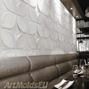 Op de afbeelding: Een witte, getextureerde wandpaneel met een herhalend, gebogen ontwerp. Het paneel is geïnstalleerd boven een bruine, gestoffeerde bank in een restaurant. De tekst "ArtMoldsEU" is onderaan zichtbaar.