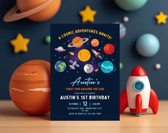 Może przedstawiać: Granatowe zaproszenie z motywem kosmicznym, z planetami, rakietą i tekstem "A Cosmic Adventures Awaits!". Ogłasza "Austin's 1st Birthday" 12 października. Ozdobne planety i gwiazdy otaczają zaproszenie.