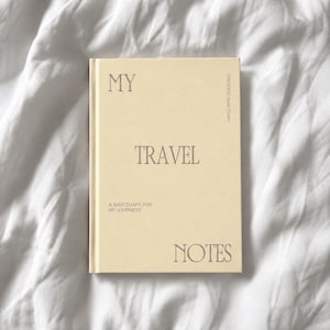 以下が含まれることがあります： クリーム色のハードカバーノートで、表紙にはセリフ体のフォントでMY TRAVEL NOTESという文字が印刷されています。表紙にはさらに小さな文字でA SANCTUARY FOR MY JOURNEYSおよびCRESCENT SANCTUARYというテキストが記載されています。