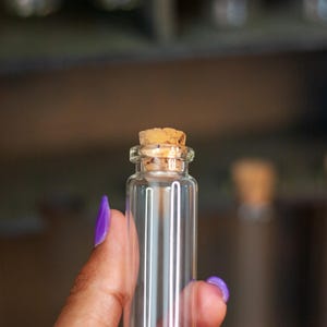 close up view of glass vial with cork lid from a rustic wooden apothecary box