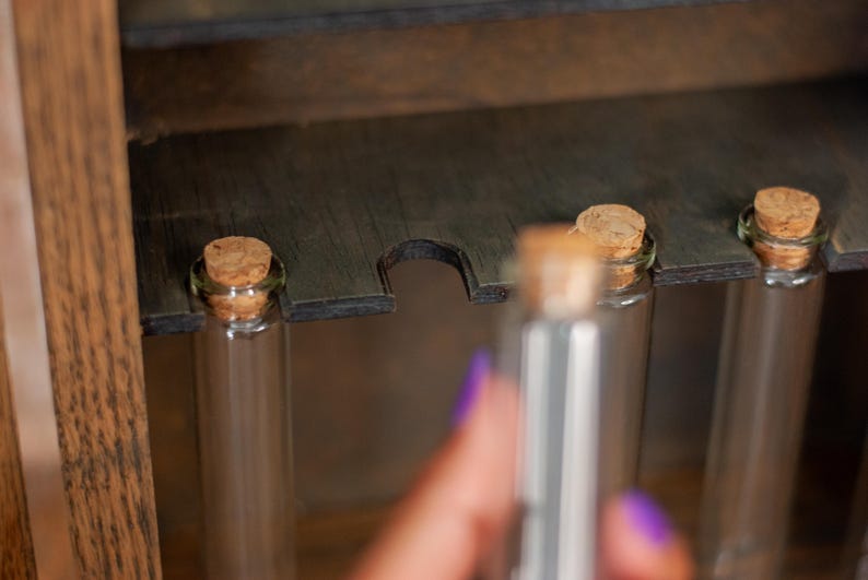 close up view of glass vials with cork lids from a rustic wooden apothecary box