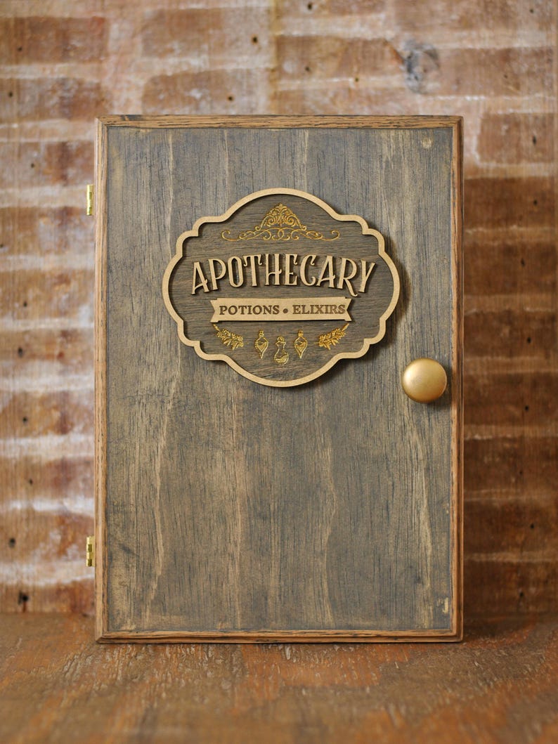 Rustic wooden apothecary-style box with bronze and gold accents with 'Apothecary Potions & Elixirs' label on a wooden background