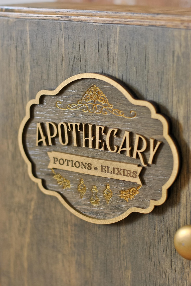 Close up view of rustic wooden apothecary-style box with bronze and gold accents with 'Apothecary Potions & Elixirs' sign