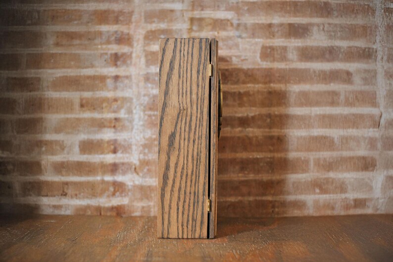 Side view of rustic wooden apothecary box on a wooden tabletop in front of a brick background