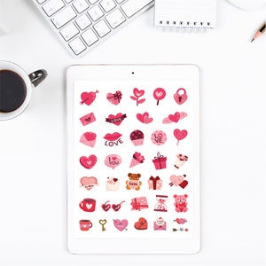 Puede incluir: Una hoja de pegatinas de San Valent&iacute;n de color rosa y rojo con corazones, cupcakes, ositos de peluche y otras im&aacute;genes rom&aacute;nticas. Las pegatinas dicen "Love", "I Love You" y "Be Mine".