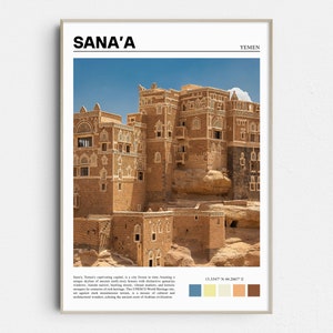 May include: A framed print featuring the city of Sana'a, Yemen. The image showcases multi-story buildings with distinctive geometric windows against a clear blue sky. The print includes the city name and country.