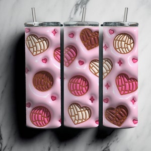 May include: Three pink stainless steel tumblers with a pattern of brown, white, and pink heart-shaped pastries. The tumblers have lids and straws.