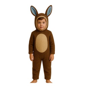 May include: A brown bunny costume for a child. The hooded jumpsuit features long sleeves, a light brown oval on the front, and tall bunny ears with blue inner ears. The child is standing against a white background.