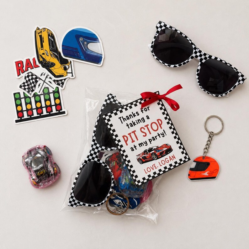 Puede incluir: Un conjunto de recuerdos de fiesta con tem&aacute;tica de carreras. Incluye gafas de sol a cuadros, un llavero con un casco naranja, pegatinas y una bolsa de golosinas con una etiqueta que dice "Thanks for taking a PIT STOP at my party!"