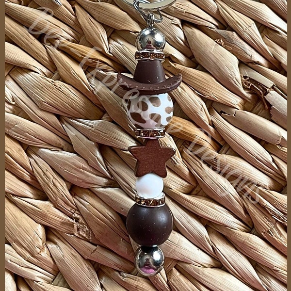 Handmade, beaded keychain with a brown cowboy hat! Lobster clasp on interchangeable bar, wood star, animal print bead, boot charm, spacers