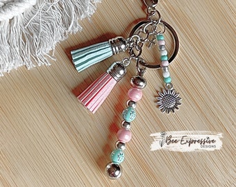 Handmade Beaded Keychain: Cross Inlay, Sunflower Charm, Suede Tassels