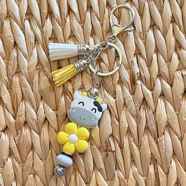 Handmade, fun yellow daisy and cow focal beaded keychain! Silver, lobster claw clasp, interchangeable, rhinestone bead, lentil bead, tassels