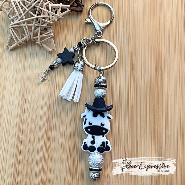 Handmade, ADORABLE, silicone COW with cowboy hat keychain! Lobster claw clasp, rhinestone spacers, beaded tassel w/ wood star & cross charm