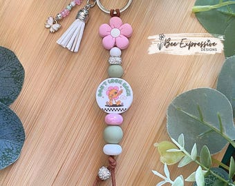 Handmade, Daisy flower, “Don’t Look Back” keychain: silicone beads, beaded tassel with a butterfly charm!
