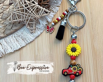 Beaded, silicone sunflower and red truck keychain! Lobster clasp with keyring, acrylic and wood beads, beaded tassel and a butterfly charm!