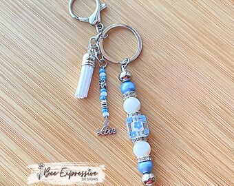 Beaded, baby blue & white, keychain! Lobster or swivel clasp, wood and acrylic beads, beaded tassel with silver flowers and a LOVE charm