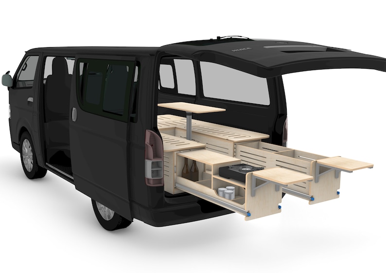 May include: A black van with the back doors open, revealing a custom built-in wooden kitchen with a fold-down table, a stove, and storage drawers.