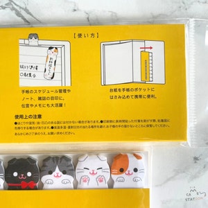 May include: A set of colourful cat-shaped sticky notes with different expressions. The notes are designed to be used as bookmarks or for marking pages in a planner or notebook. The notes are packaged in a clear plastic bag with instructions on how to use them.