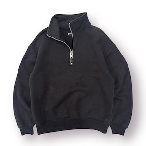 May include: Black sweatshirt with a high collar and a silver zipper down the front. The sweatshirt has long sleeves and a ribbed hem and cuffs. The brand name is visible on the inside of the collar.