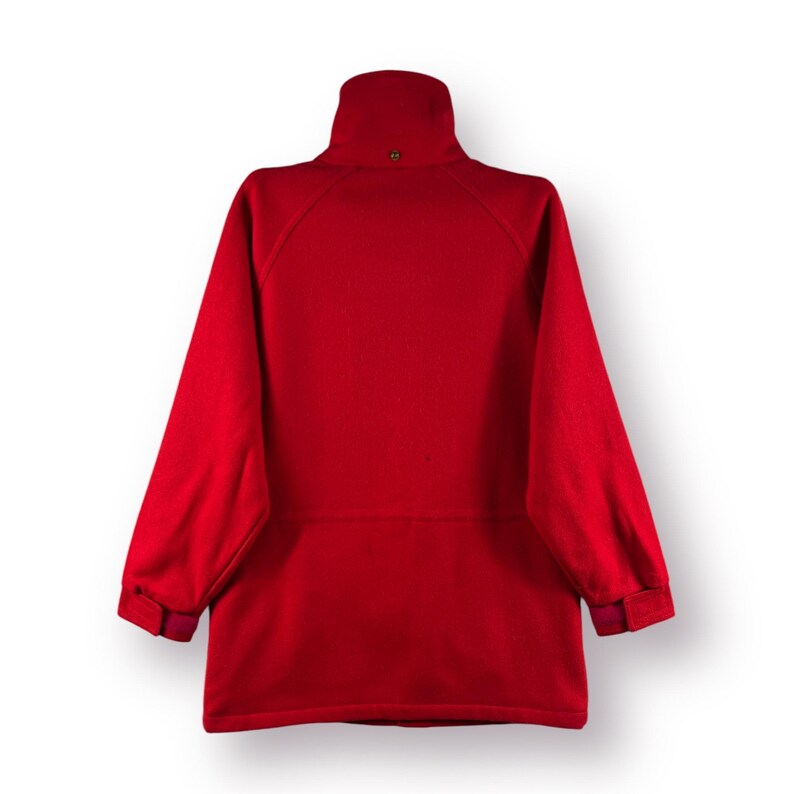 May include: A red fleece jacket with a high collar and zipper closure. The jacket has a small pocket on the left chest and two pockets on the lower front.