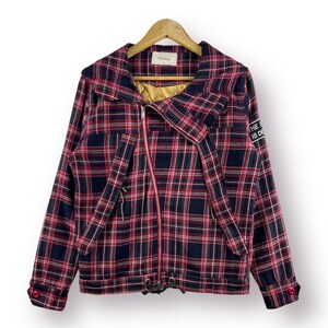 Puede incluir: Una chaqueta de cuadros rojos y negros con cierre de cremallera y capucha. La chaqueta tiene un parche en la manga que dice "THE FUTURE IS DEAD".