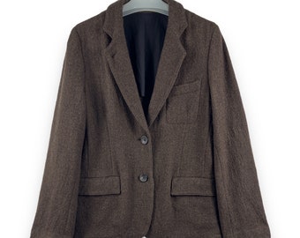 May include: A brown tweed blazer with two button closures and a single pocket on the left side.