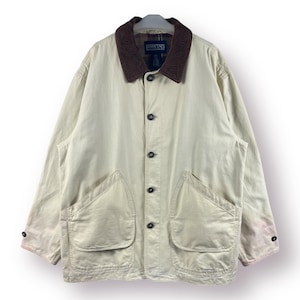 Puede incluir: Una chaqueta de lona beige con cuello de pana y forro de cuadros. La chaqueta tiene dos bolsillos grandes en la parte delantera y cierre de botones.