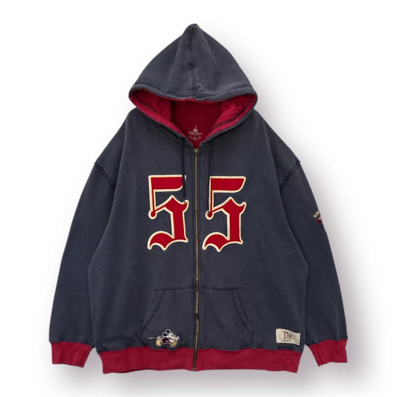 May include: Navy blue zip-up hoodie with a red interior and trim. The number "55" is prominently displayed in red with a white outline on the front. Features a hood, front pockets, and a small Mickey Mouse graphic.