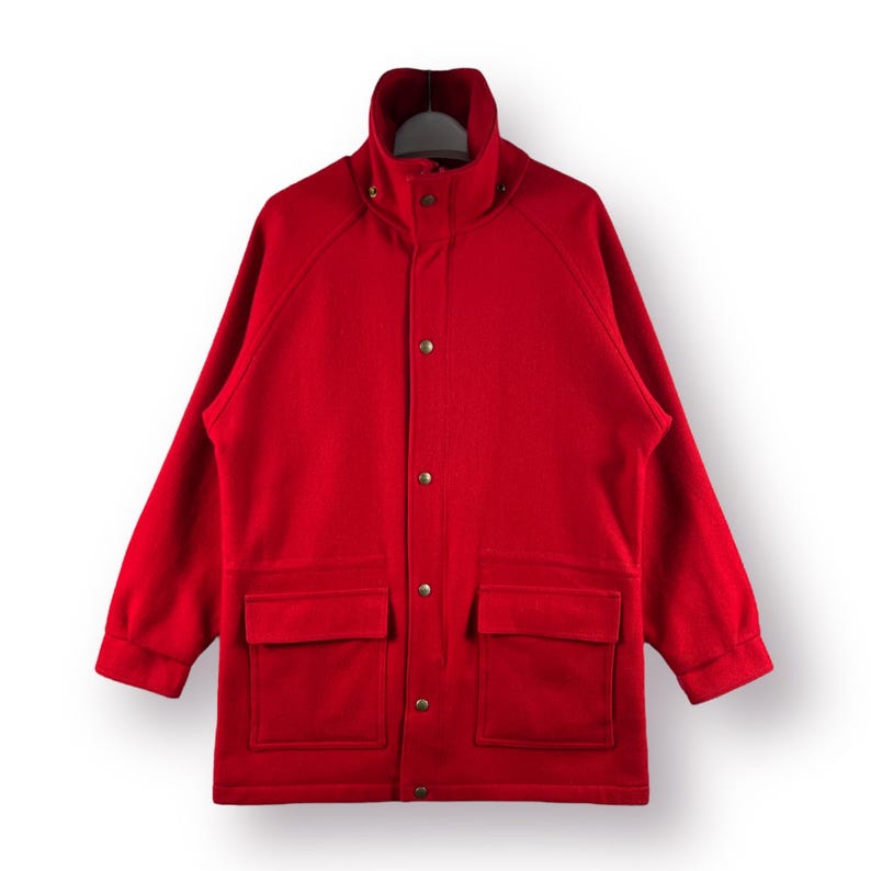 May include: A red wool jacket with a high collar, button closure, and two large pockets.