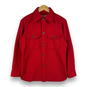 May include: A red long-sleeved button-up shirt with two large flap pockets and black buttons.