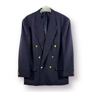 May include: A navy blue double-breasted blazer with gold buttons. The blazer has a classic fit and a smooth texture.