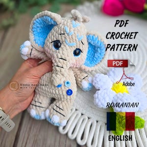 Puede incluir: Un juguete de elefante tejido a ganchillo en beige con detalles azules en las orejas y los pies. El elefante tiene ojos negros y costuras decorativas azules. La imagen incluye el texto "PDF Crochet Pattern" y banderas rumana e inglesa.