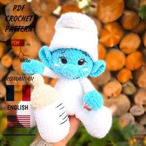 Pode incluir: Boneca Smurf de crochê feita à mão com chapéu e roupa brancos, segurando uma mamadeira branca e bege. A boneca é azul com detalhes em azul. A imagem inclui o texto "PDF CROCHET PATTERN" e "ROMANIAN ENGLISH".
