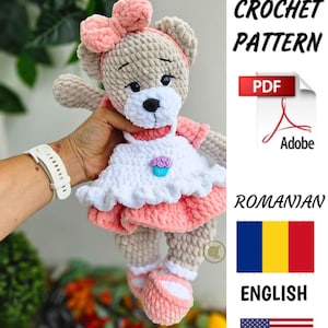 May include: Crochet pattern for a pink and gray teddy bear wearing a white dress with a pink trim and a cupcake design. The pattern is available in both Romanian and English languages. PDF download.