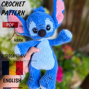 Può includere: Un peluche blu all'uncinetto con grandi orecchie e un naso nero. Il giocattolo è tenuto in mano. L'immagine include il testo "PDF CROCHET PATTERN" e "ENGLISH".