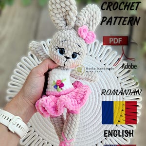May include: Crochet pattern for a ballerina bunny amigurumi toy. The bunny is wearing a pink tutu and has a pink bow on its head. The pattern is available in both English and Romanian.