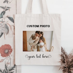 Puede incluir: Una bolsa de lona blanca con una foto de una familia de cuatro. El texto "CUSTOM PHOTO" está impreso sobre la foto y "your text here" está impreso debajo de la foto.