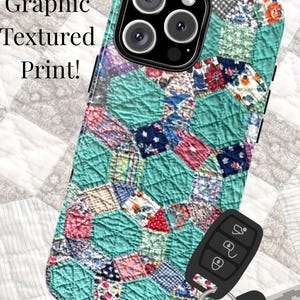 May include: A smartphone case featuring a graphic textured print of a multi-colored hexagonal patchwork quilt pattern. The case includes the text Graphic Textured Print! and has a black camera module cutout at the top with three circular lenses.