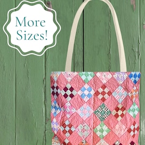 May include: A tote bag featuring a patchwork quilt design with a repeating diamond pattern in shades of pink, white, blue, green, and red. The bag has two off-white fabric handles and a white scalloped graphic with the text More Sizes! in teal.