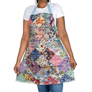 May include: A patchwork apron with a light blue neck strap. The apron is made of various fabric squares in floral and patterned designs, including red, blue, and pink. The apron is a kitchen or craft accessory.