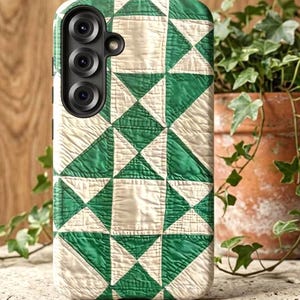 May include: A smartphone case featuring a repeating geometric quilt pattern in shades of forest green and off-white. The design consists of alternating squares and triangles arranged in a grid, with a cutout for a triple-lens camera system.